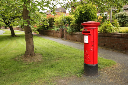 Victorian red post box on a residential tree lined street in Wilmslow, United Kingdom